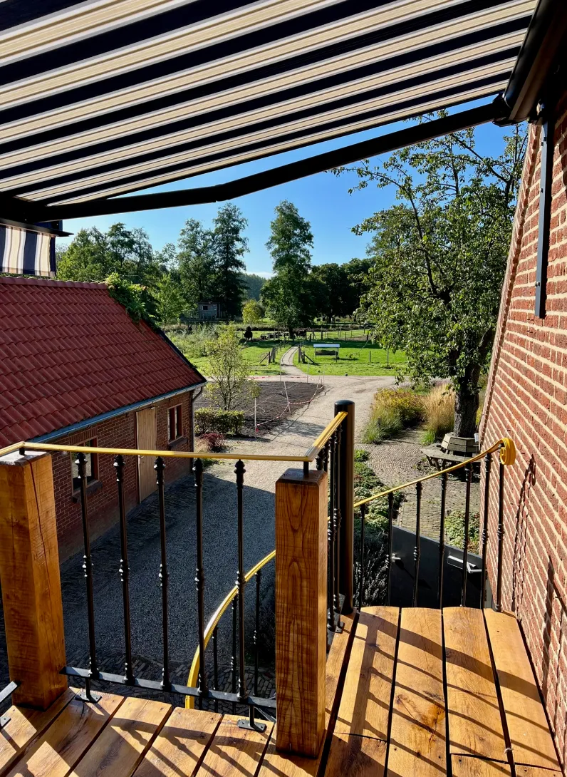 Houten balkontrap met uitzicht op de oprit en de natuur