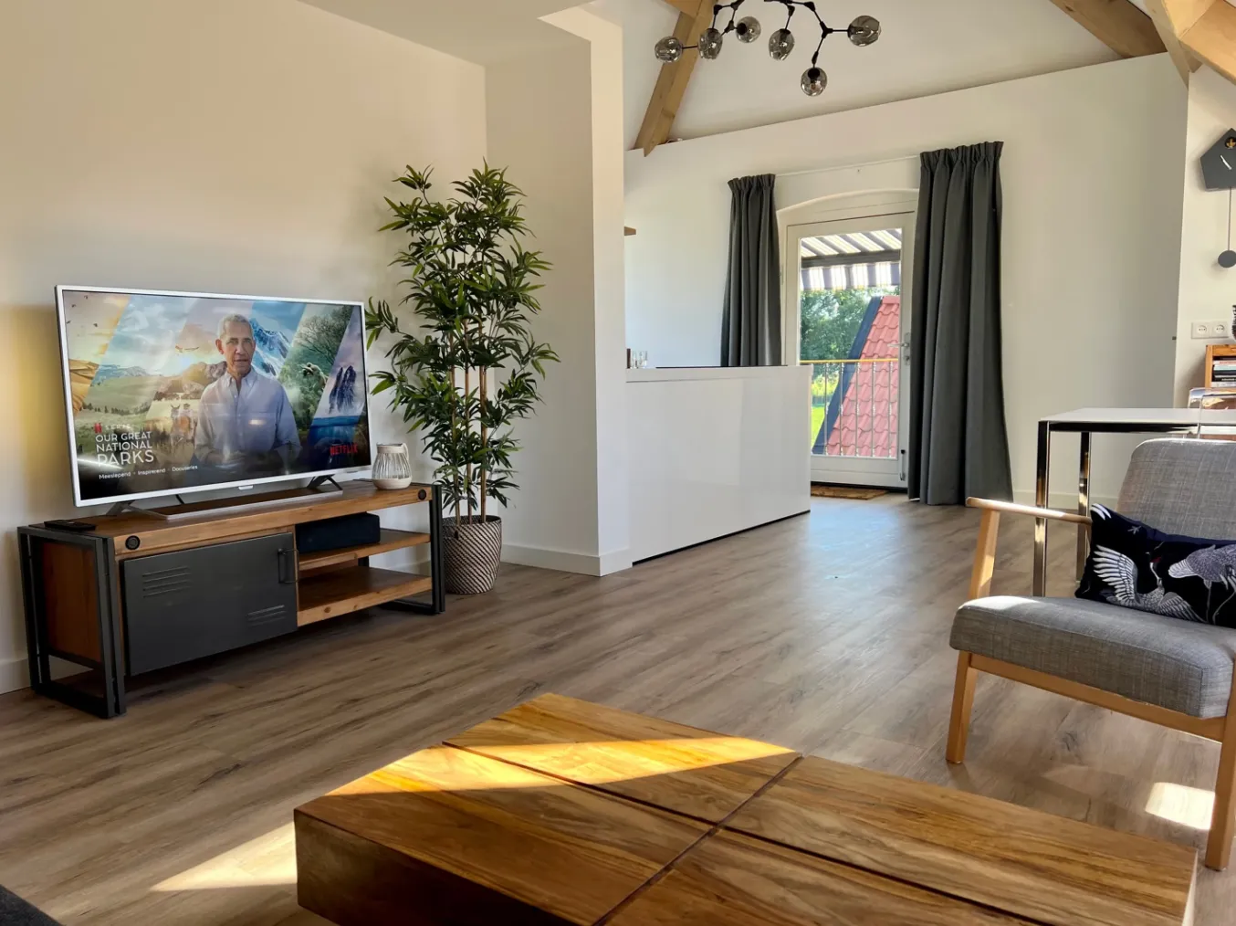 Woonkamer met zithoek, smart-tv en doorkijk naar het balkon
